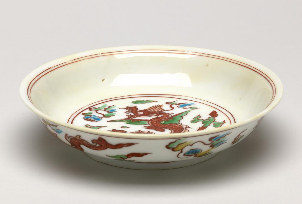 An image of Dish. Production Place: China. A polychrome ‘winged dragon’ dish, Hongzhi/Zhengde, mark Shangyong ( Imperial use). Yellowish body, light scratches), diameter 15 cm.