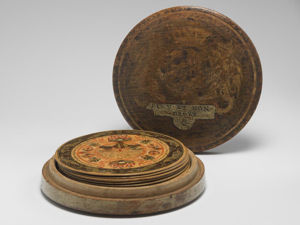 An image of Woodwork. Box of roundells. Box containing twelve trenchers. Wood, painted, gold decoration, height, box, 3.2 cm, diameter, box, 16.6 cm, diameter, roundels, 13.2 cm, circa 1600. Renaissance. Elizabeth I. English.