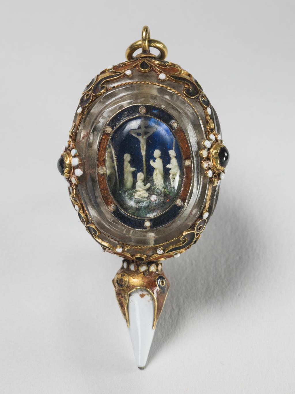 An image of Pendant/ Jewellery. Unknown Maker, Spanish. Triangular with three jewels and oval panels containing against a blue background three scenes from the life of Christ, the Adoration of the Shepherds, the Crucifixion and the Resurrection - the figures in white, the drop also being white enamel over the gold. Enamelled gold and crystal, height, whole, 5.1, cm, circa 1500-1660. Renaissance.