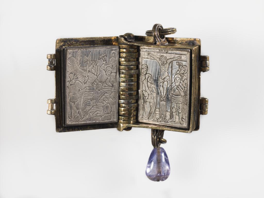 An image of Pendant Book. Jewellery/Pendant. Silver-gilt, with leaves made of silver and engraved with scenes from the Passion. Perhaps for attaching to a rosary, with pendant amethyst. Scenes: Annunciation, Nativity, Last Supper, Agony in the Garden, Kiss of Judas, Christ before Pilate, Scourying of Christ, The Mocking of Christ, Christ Carrying the Cross, the Erection of the Cross, Christ being Nailed to the Cross, the Crucifixion Deposition, Entombment, Resurrection, Christ Child Enthroned, a Pope and a female Saint. Silver-gilt, height, whole, 6.0 cm, width, whole, 2.8 cm, circa 1500- circa 1700. German.