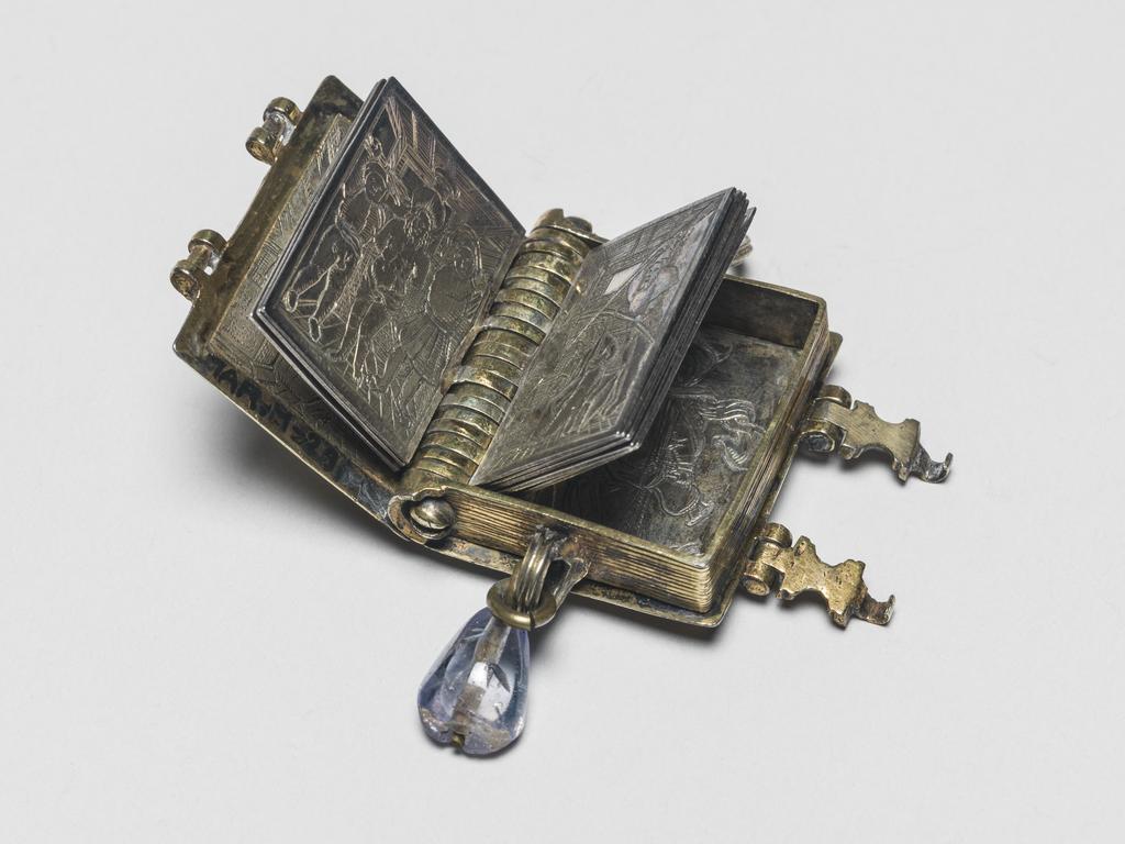 An image of Pendant Book. Jewellery/Pendant. Silver-gilt, with leaves made of silver and engraved with scenes from the Passion. Perhaps for attaching to a rosary, with pendant amethyst. Scenes: Annunciation, Nativity, Last Supper, Agony in the Garden, Kiss of Judas, Christ before Pilate, Scourying of Christ, The Mocking of Christ, Christ Carrying the Cross, the Erection of the Cross, Christ being Nailed to the Cross, the Crucifixion Deposition, Entombment, Resurrection, Christ Child Enthroned, a Pope and a female Saint. Silver-gilt, height, whole, 6.0 cm, width, whole, 2.8 cm, circa 1500- circa 1700. German.