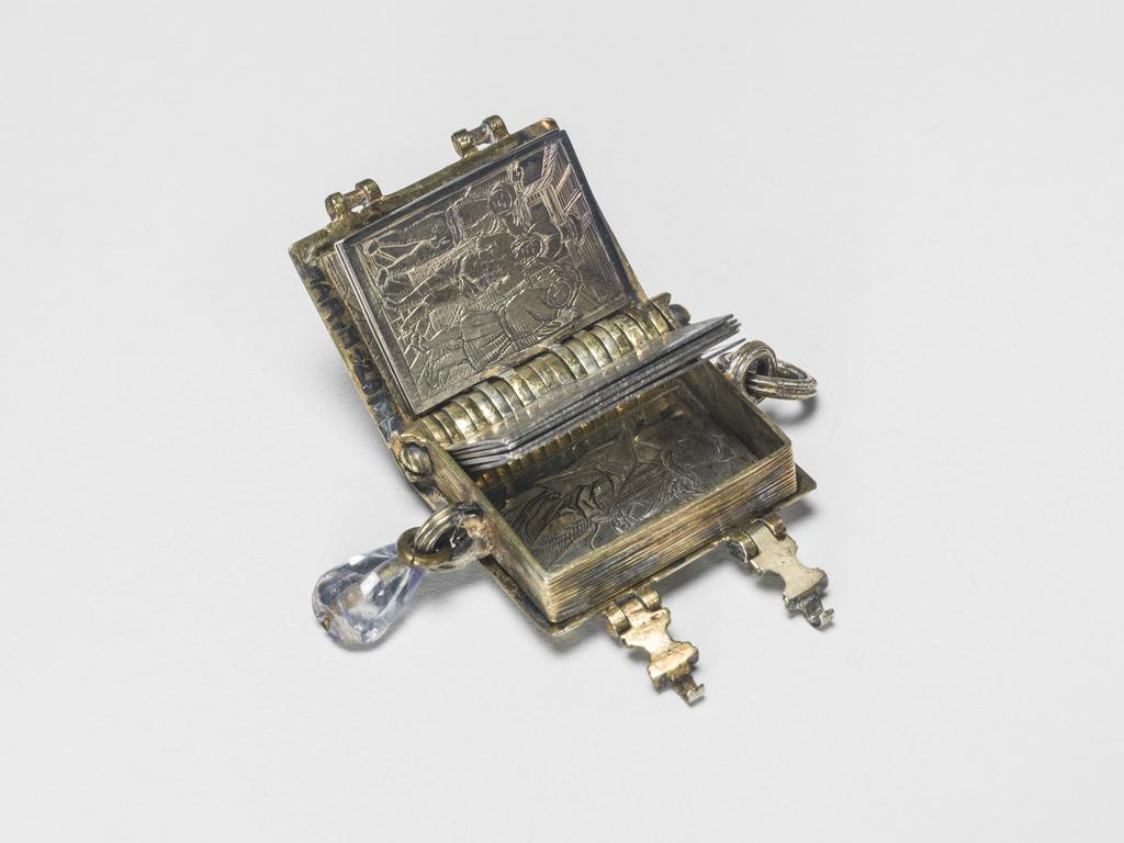 An image of Pendant Book. Jewellery/Pendant. Silver-gilt, with leaves made of silver and engraved with scenes from the Passion. Perhaps for attaching to a rosary, with pendant amethyst. Scenes: Annunciation, Nativity, Last Supper, Agony in the Garden, Kiss of Judas, Christ before Pilate, Scourying of Christ, The Mocking of Christ, Christ Carrying the Cross, the Erection of the Cross, Christ being Nailed to the Cross, the Crucifixion Deposition, Entombment, Resurrection, Christ Child Enthroned, a Pope and a female Saint. Silver-gilt, height, whole, 6.0 cm, width, whole, 2.8 cm, circa 1500- circa 1700. German.