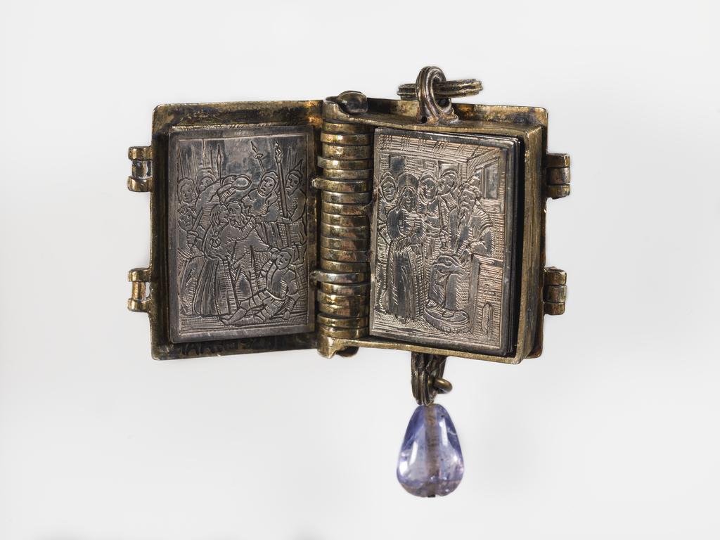 An image of Pendant Book. Jewellery/Pendant. Silver-gilt, with leaves made of silver and engraved with scenes from the Passion. Perhaps for attaching to a rosary, with pendant amethyst. Scenes: Annunciation, Nativity, Last Supper, Agony in the Garden, Kiss of Judas, Christ before Pilate, Scourying of Christ, The Mocking of Christ, Christ Carrying the Cross, the Erection of the Cross, Christ being Nailed to the Cross, the Crucifixion Deposition, Entombment, Resurrection, Christ Child Enthroned, a Pope and a female Saint. Silver-gilt, height, whole, 6.0 cm, width, whole, 2.8 cm, circa 1500- circa 1700. German.