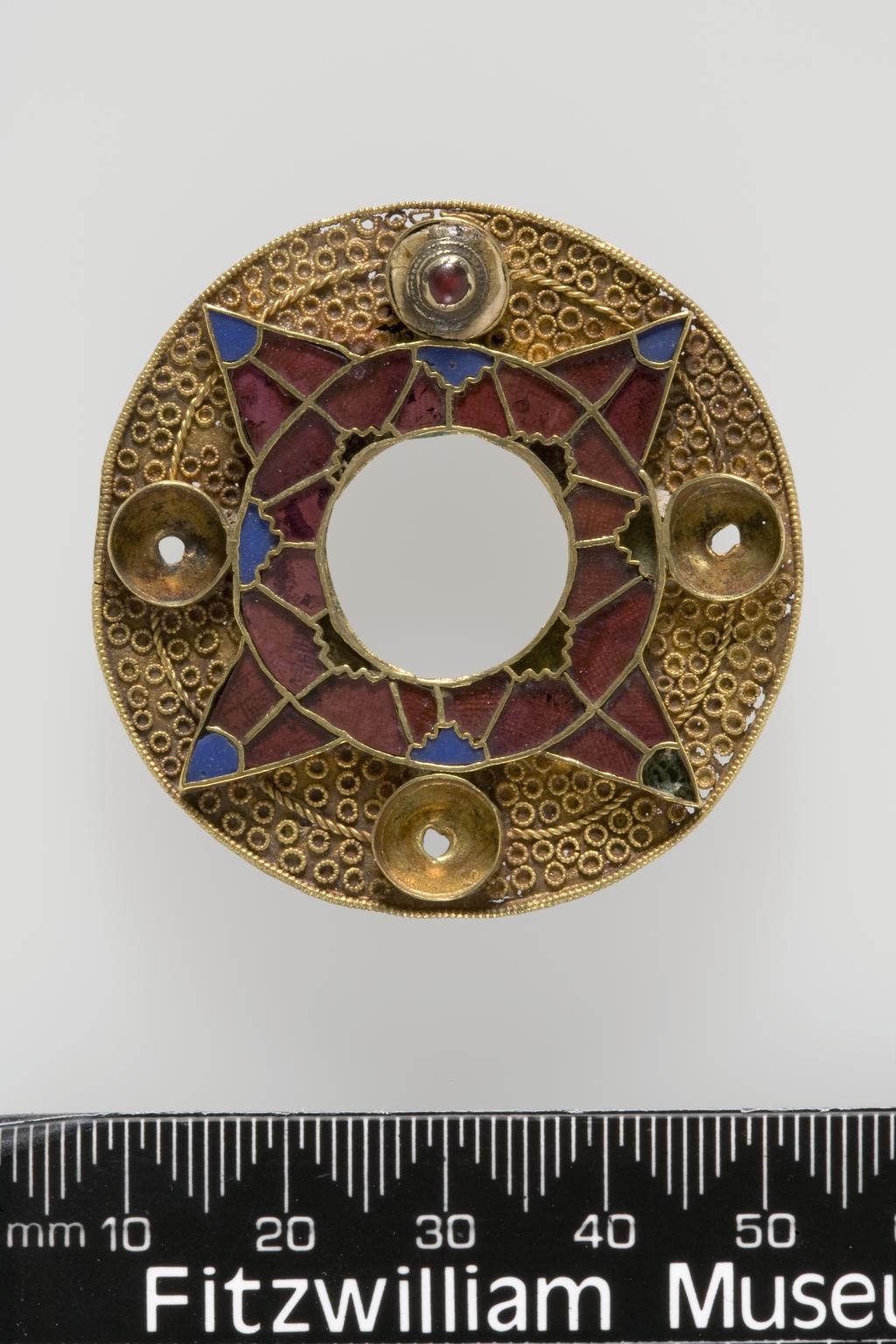 An image of Jewellery/Bracteate. Gold, decorated with a concentric design of stamped chequered triangles, height 3.2cm, depth 2.8cm, circa 500-600. Anglo-Saxon. From 19th century excavations of a cemetery at the King's Field, Faversham, Kent.
