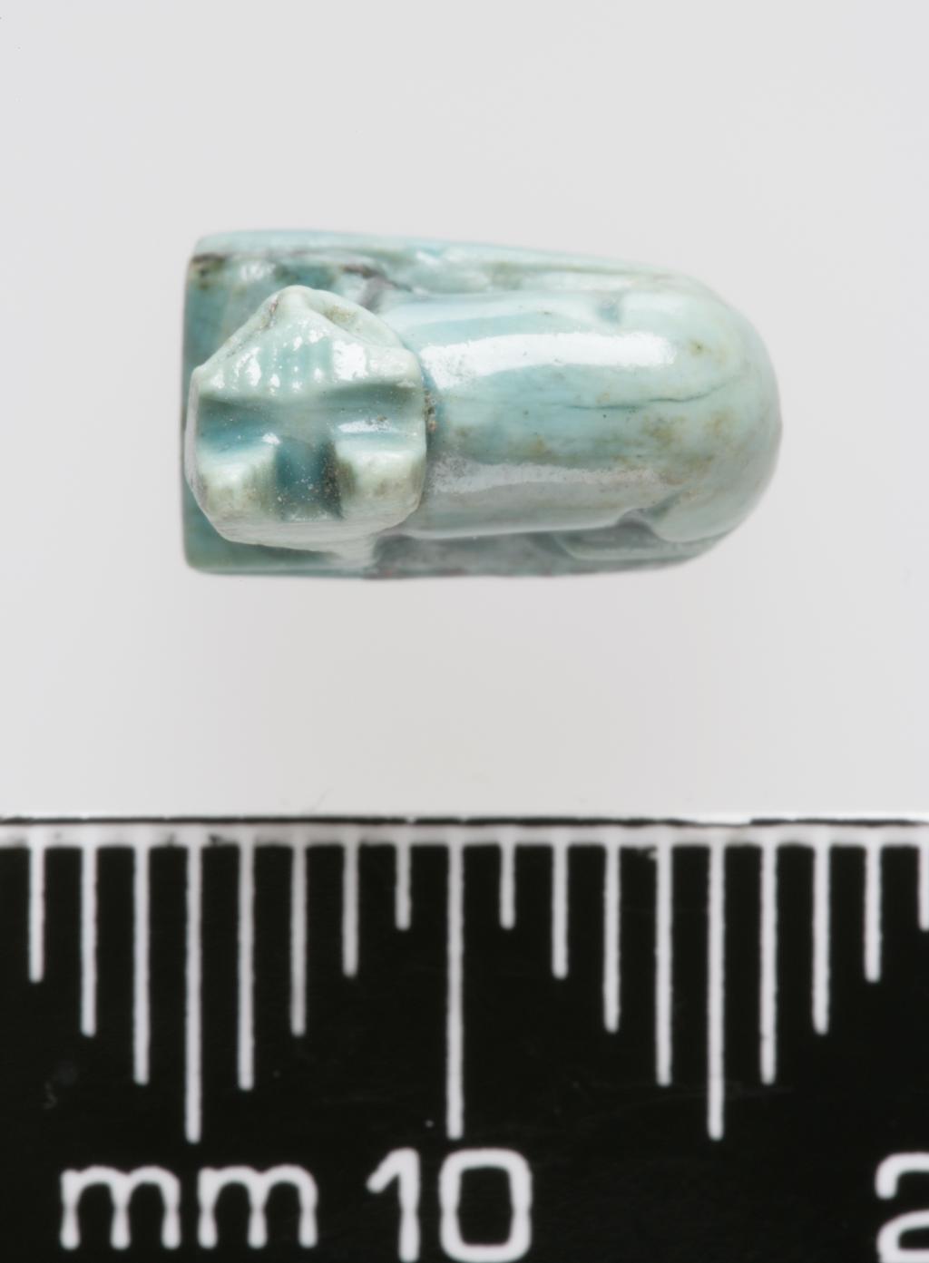 An image of Jewellery. Amulet. Cat, inscribed with sun disks and uraei on base. Production Place/Find Spot: Egypt. Length 0.011 m, width 0.01 m. 