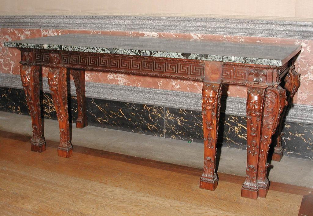 An image of Furniture. Console table/side table. Unknown maker, Italy. Console table of carved, gessoed and gilt wood with nymphs, putti, masks, scrollwork and floral swags and a black and white marble slab top. Carved and gilded wood, black and white marble top, width, whole, 218 cm, circa 1700. Baroque.
