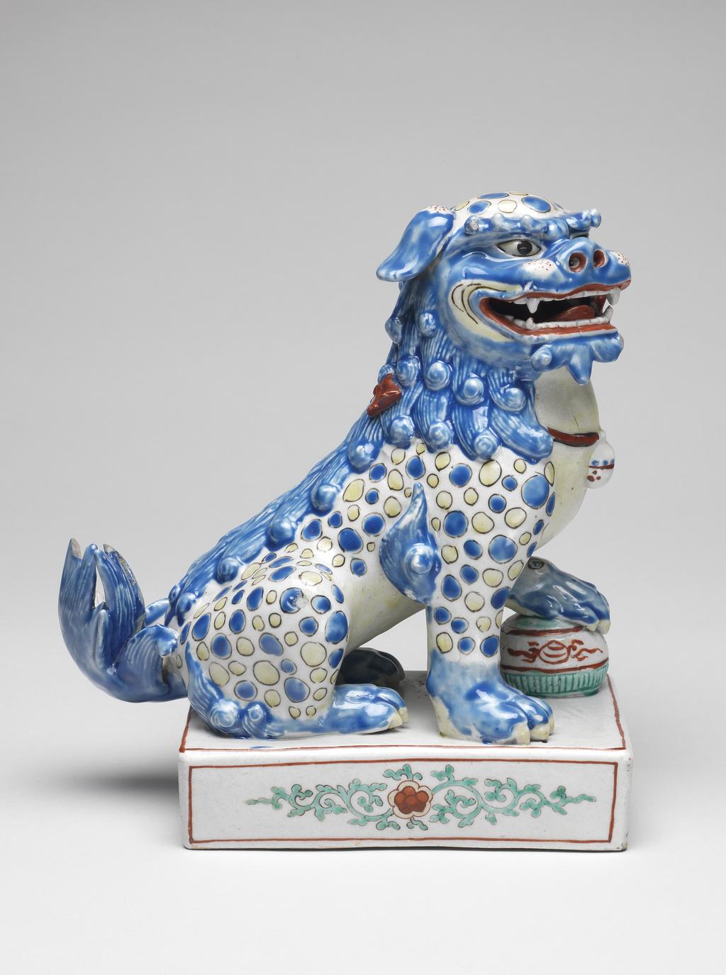 An image of Animal figure. Unknown maker, Japan, Arita. Kakiemon. Porcelain Buddhist lion (karashishi). The base is decorated with plum blossoms. Moulded, and painted in enamels, circa 1680. Edo Period (1615-1868). 