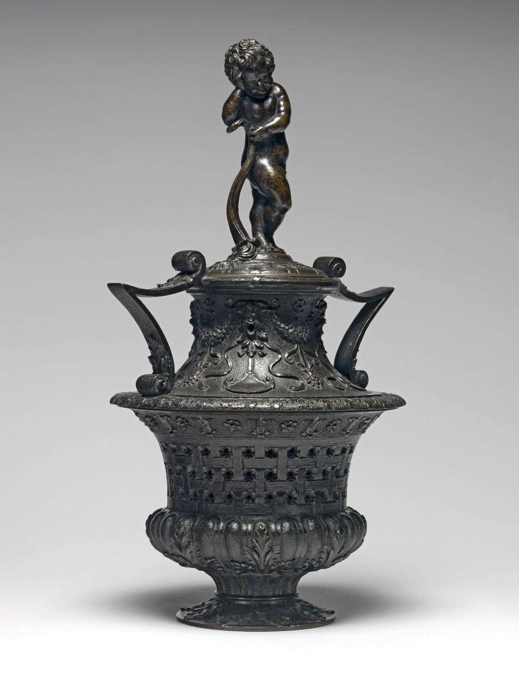 An image of Cassolette and cover with a funerary genius. Vincenzio Grandi (Italian sculptor, 1493-1577/78), and/or Gian Girolama Grandi (Italian, 1508-1560). Vase-shaped, with pierced sides, and two v-shaped handles, the cover surmounted by a standing putto leaning on an extinguished torch. Copper alloy, probably bronze, cast, height, whole, 34.1, cm, 1530-1560. Renaissance.